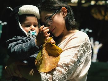 Close-up of mother carrying son at night