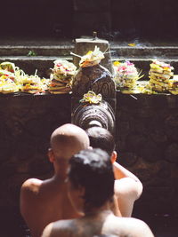 Midsection of woman with flowers in water