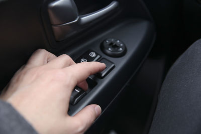 Close-up of hand holding smart phone in car