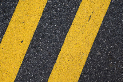 Close-up of yellow arrow symbol on road