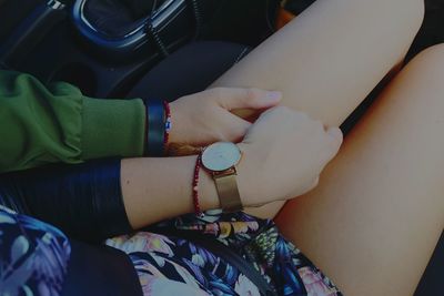 Cropped hand of boyfriend touching girlfriend thigh in car