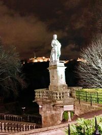 Statue in city at night