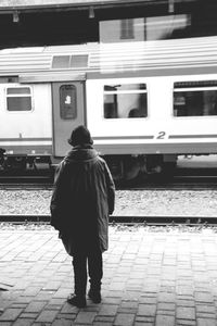 Rear view of men walking on railroad track