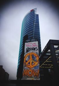 Low angle view of text against sky in city