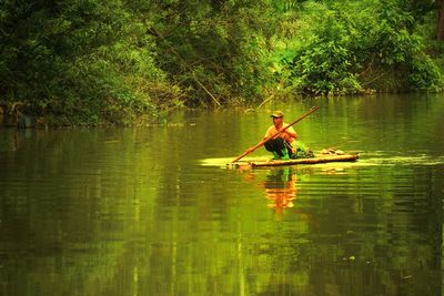 Man sitting on boat in lake