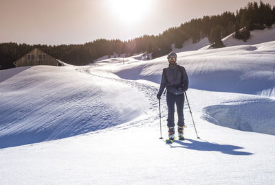 Portrait of man skiing on snow covered field