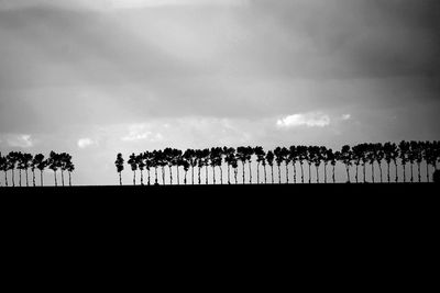 Silhouette people on landscape against sky