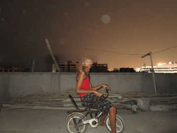 Boy riding bicycle at night