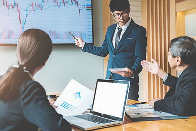 Colleagues working over graph at desk in office