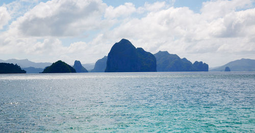 Scenic view of sea and mountains against sky