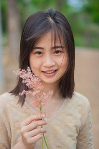 Portrait of a smiling girl holding plant