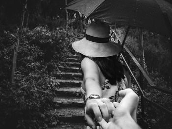 Rear view of a woman holding umbrella