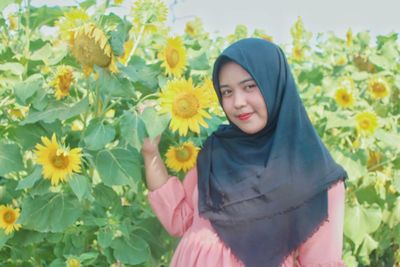 Low section of woman standing on yellow flowering plants