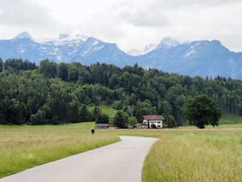 Scenic view of road by mountains against sky