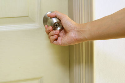 Close-up of hand holding metal door