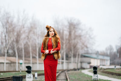 Portrait of woman standing on snow covered tree