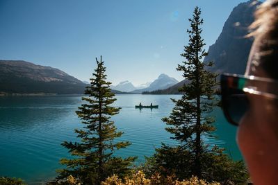 Scenic view of lake and mountains against clear blue sky