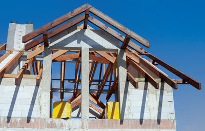 Low angle view of house on beach against clear blue sky