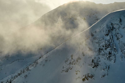 Scenic view of snow covered mountains against sky