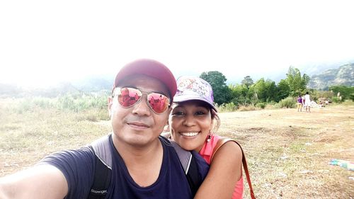 Portrait of young couple standing on field