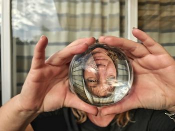 Upside down image of woman reflecting in crystal ball