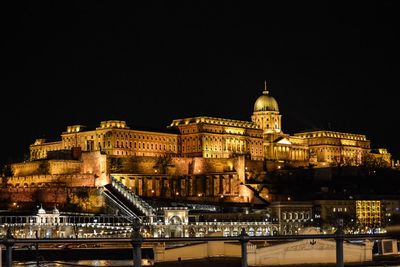 Illuminated city against sky at night