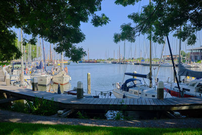 Sailboats moored on lake against sky