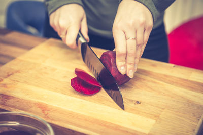 Close-up of hand holding leaf on cutting board