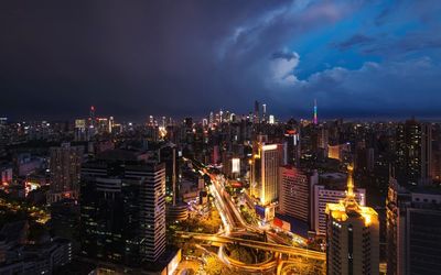 High angle view of illuminated city buildings against sky