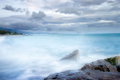 Scenic view ofmisty sea and rocks  against sky