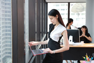 Young woman using phone while standing on table