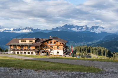 Houses by mountain against sky