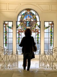 Rear view of woman standing on staircase in building