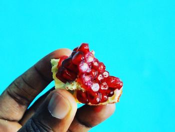 Midsection of man holding fruit against blue background