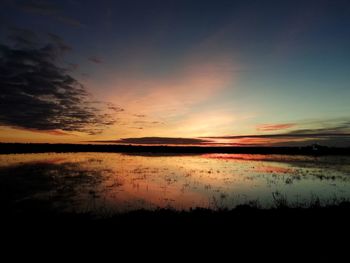 Scenic view of lake against sky at sunset