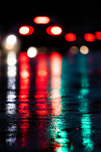 Defocused image of illuminated lights on wet street
