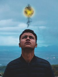 Portrait of young man looking away against sky