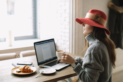 Side view of woman sitting on table