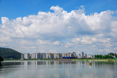 Scenic view of lake against sky in city