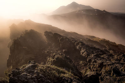 Aerial view of mountains against sky during sunset