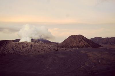 Smoke emitting from volcanic mountain against sky