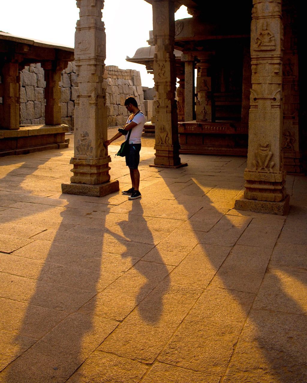 shadow, architecture, full length, one person, built structure, real people, sunlight, lifestyles, architectural column, day, building exterior, leisure activity, history, nature, building, the past, outdoors, men, city, paving stone, colonnade