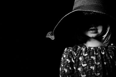 Close-up of young woman over black background