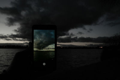 Scenic view of sea against cloudy sky at sunset