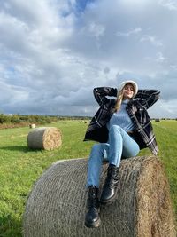 Rear view of woman sitting on hay