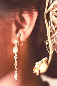 Cropped image of woman wearing gold earrings