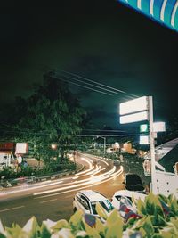 Illuminated city street against sky at night
