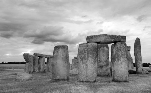 Old ruins in field against cloudy sky