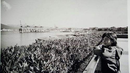 Woman on sea shore against sky