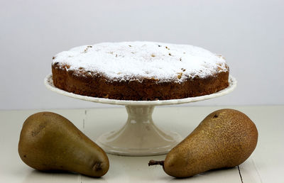 Close-up of homemade cake and two pears